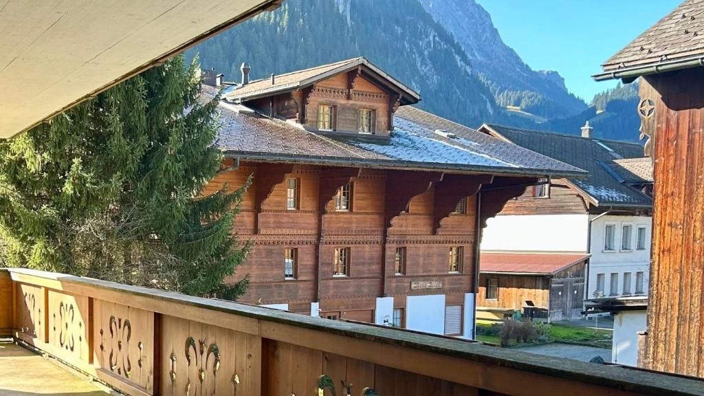 格施塔德Gstaad - Luxury Flat in Saanen的一座大木结构建筑,背景是一座山