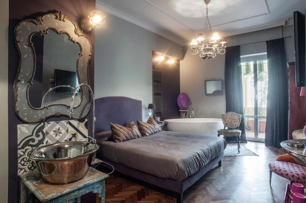 a bedroom with a bed and a tub and a mirror at Terrazza Munira Trastevere in Rome