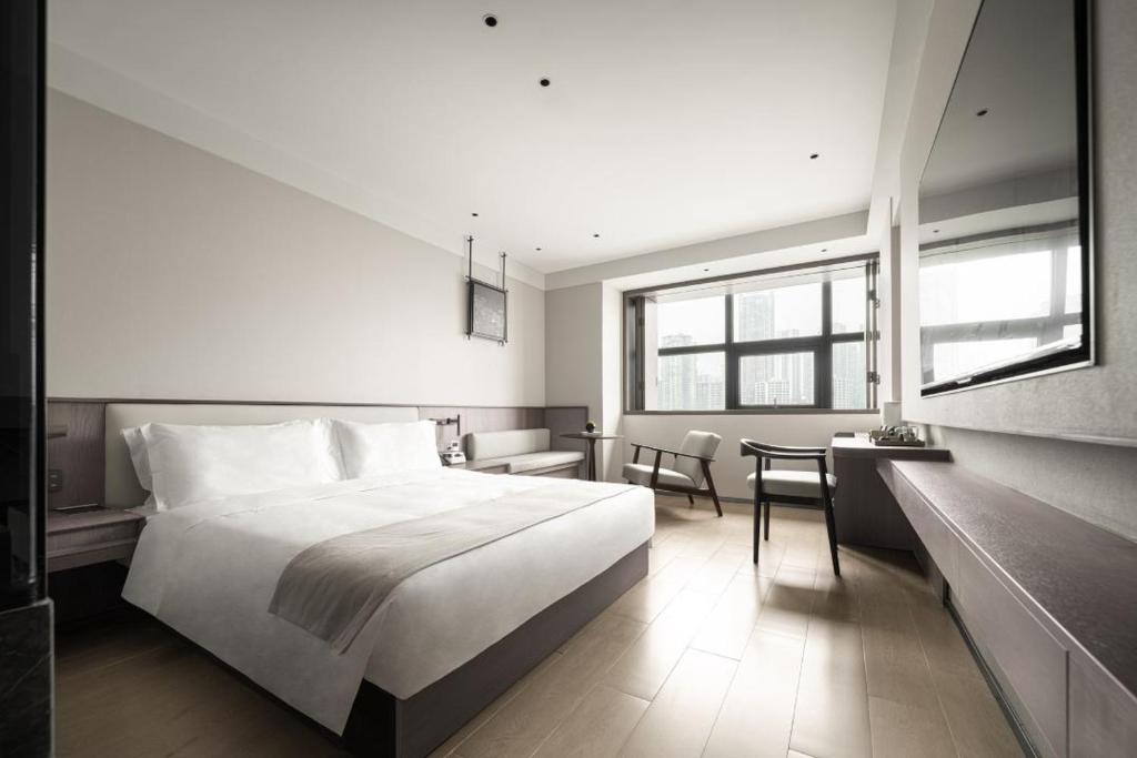 Postel nebo postele na pokoji v ubytování Walling Hotel - Chongqing hongyadong jialingjiang binjianglu
