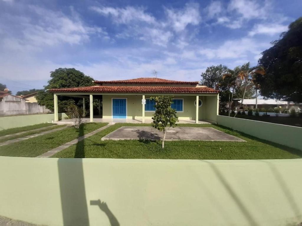 a small house with a blue door at Casa para família - Araruama RJ in Araruama
