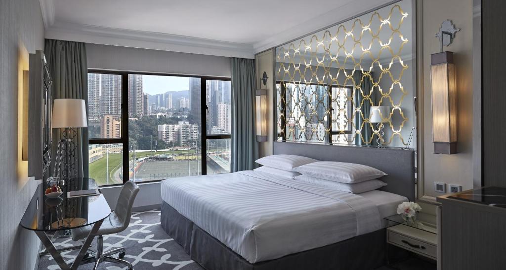 um quarto com uma cama grande e uma janela grande em Dorsett Wanchai, Hong Kong em Hong Kong