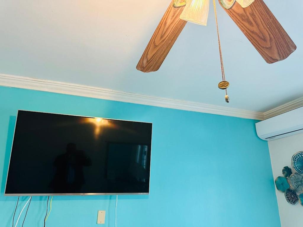 Un televisor de pantalla plana colgado del techo. en Rare Find -Beach View, en Nassau