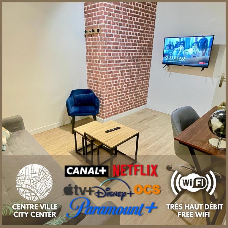 une pièce avec une table et deux chaises et une télévision dans l'établissement Le Chablis - Proche Centre & CHU, avec MiniBar, à Dijon