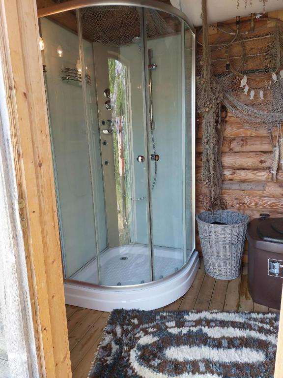 a glass shower in a room with a rug at Ohessaare mereäärne camping in Ohessaare