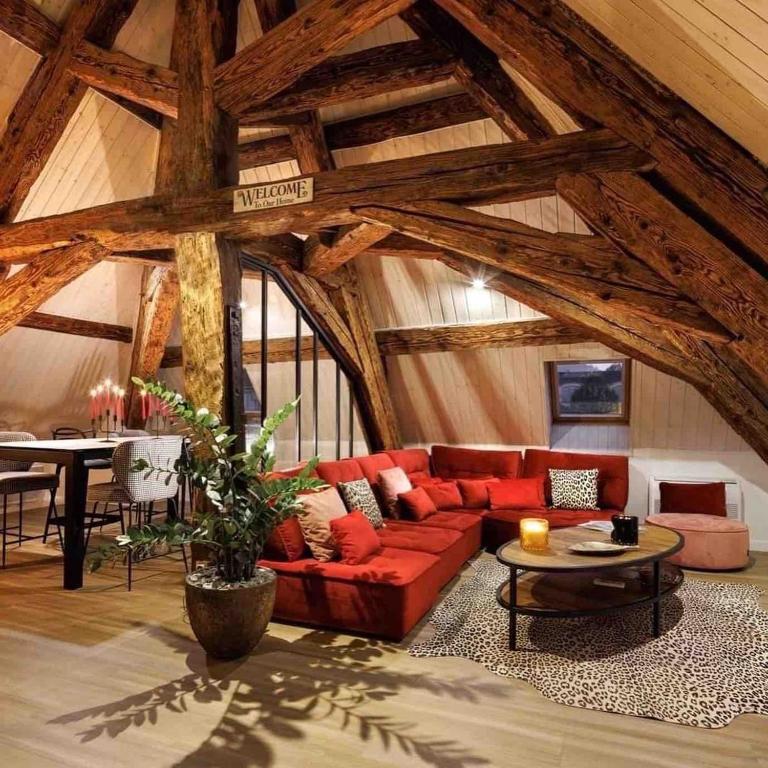 un salon avec un canapé rouge et une table dans l'établissement Spacious apartment in the heart of the city center, à Lons-le-Saunier