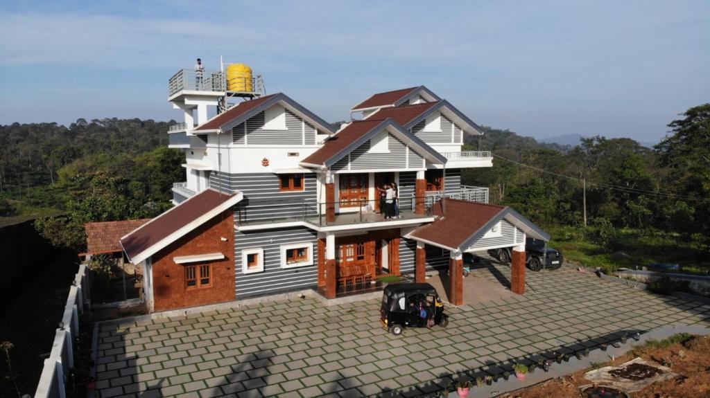 a house with a cow standing in front of it at Mountain Breeze Coorg in Madikeri