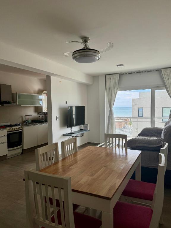 a kitchen and dining room with a wooden table and chairs at Mi Ruca in Puerto Madryn
