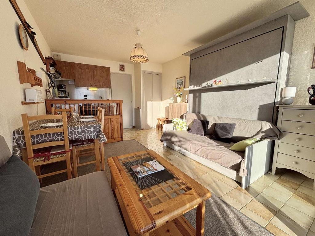 un salon avec un canapé et une table dans l'établissement Studio ski-in/ski-out à Notre-Dame-de-Bellecombe, piscine, tennis, parking - 4 personnes - FR-1-595-3, à Notre-Dame-de-Bellecombe