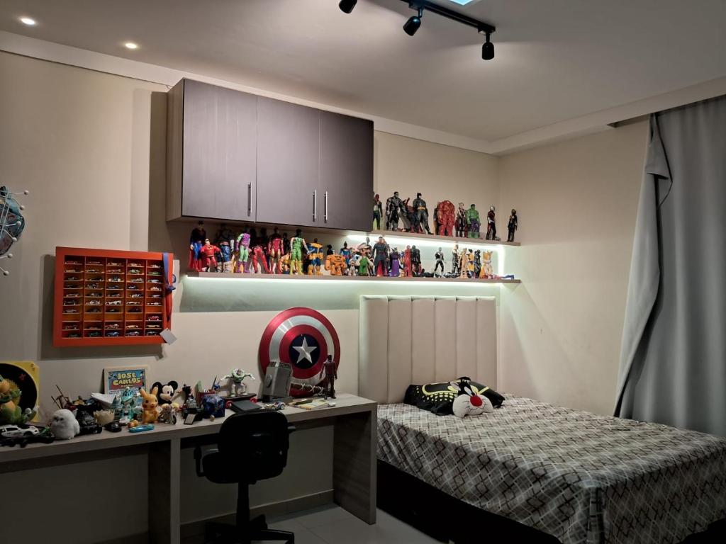 a bedroom with a bed and a desk and some figurines at Doce Lar- COP 30 in Ananindeua