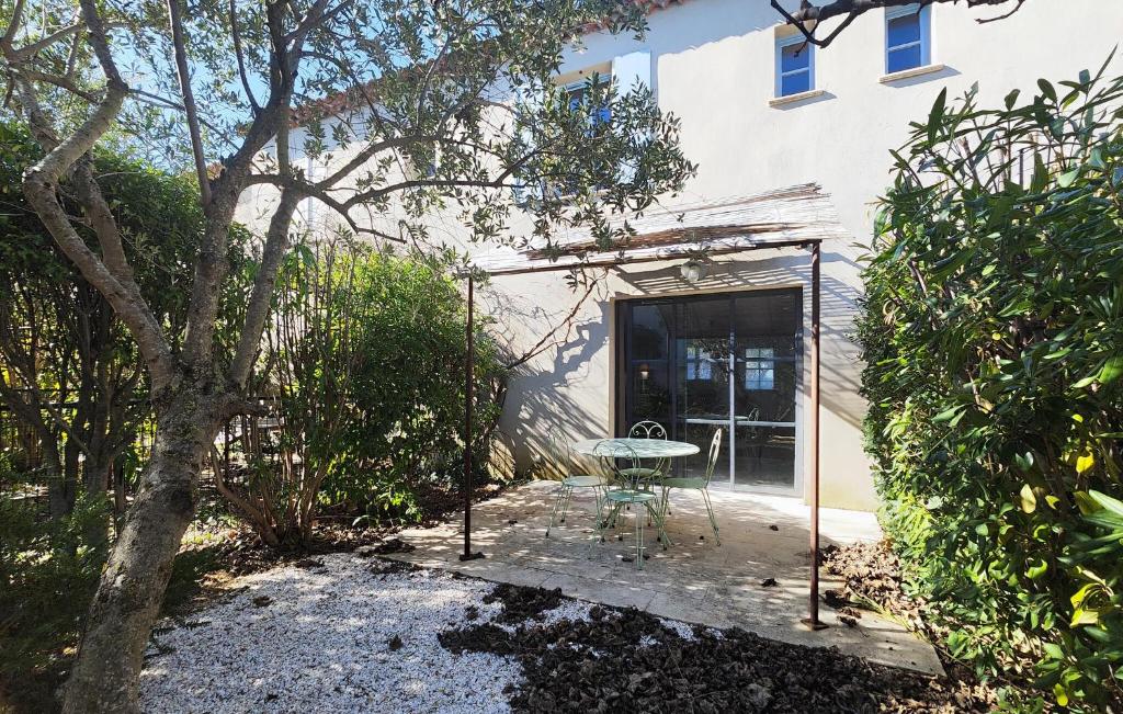 un patio avec une table en face d'un bâtiment dans l'établissement Lovely Home In Saint Laurent De La Ca, à Saint-Laurent-de-la-Cabrerisse