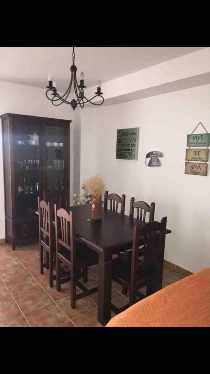 a dining room with a wooden table and chairs at Majaceite in El Bosque