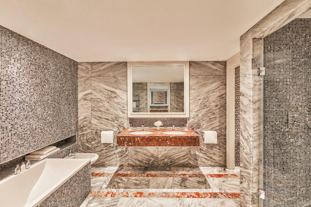 a bathroom with a tub and a sink at Hôtel Barrière Le Majestic Cannes in Cannes