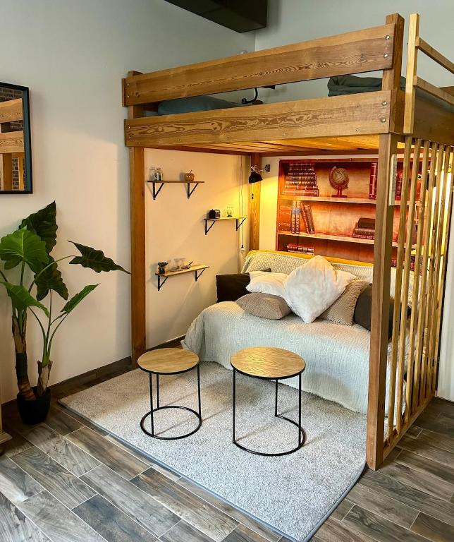 - une chambre avec un lit en bois et 2 tables dans l'établissement L'escapade en mezzanine, à Dieppe