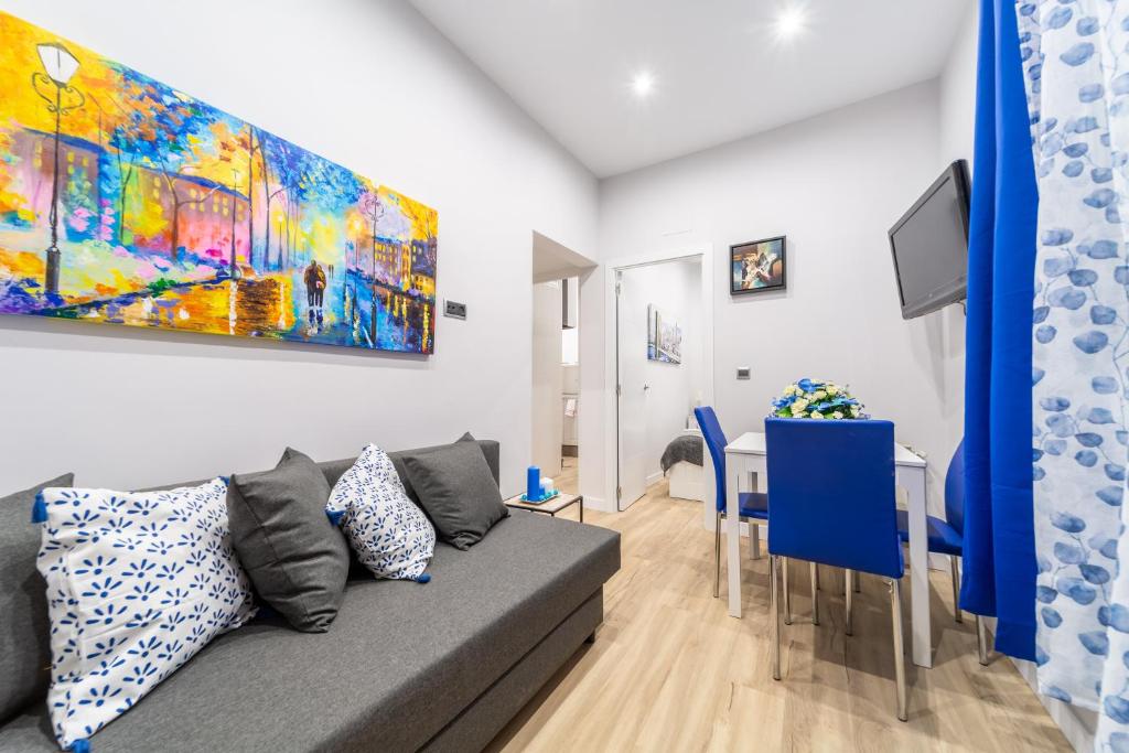 salon z kanapą i obrazem na ścianie w obiekcie Cozy Blue Apartment - Alojamiento de temporada w Madrycie