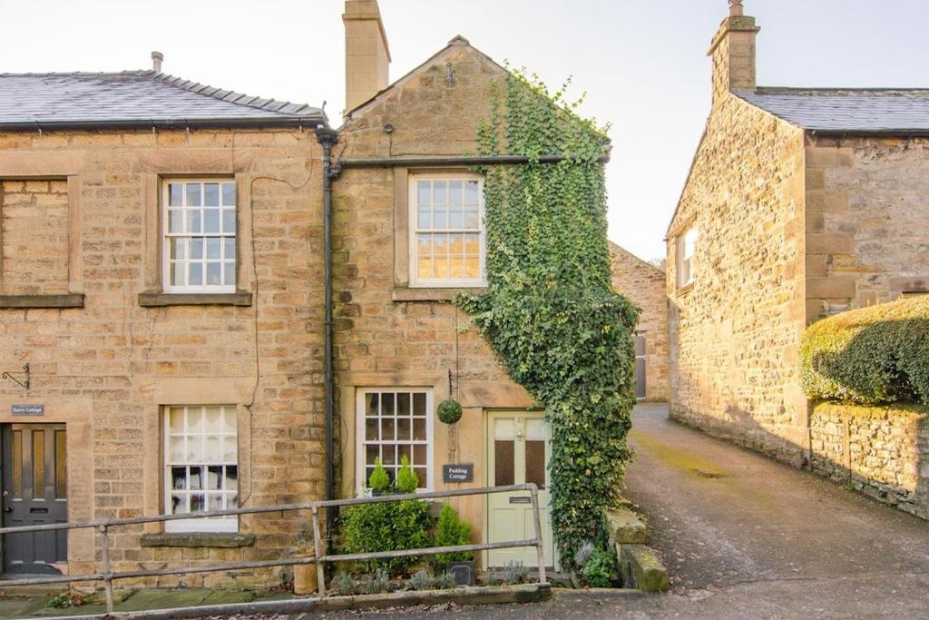 an old brick house with ivy growing on it at Pudding Cottage in Bakewell in Bakewell