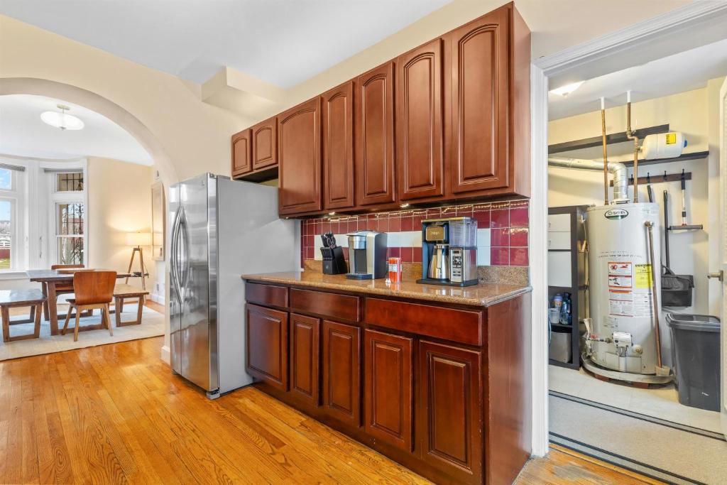a kitchen with wooden cabinets and a stainless steel refrigerator at Spacious and Central DC 3-BR Getaway Close to It All in Washington, D.C.