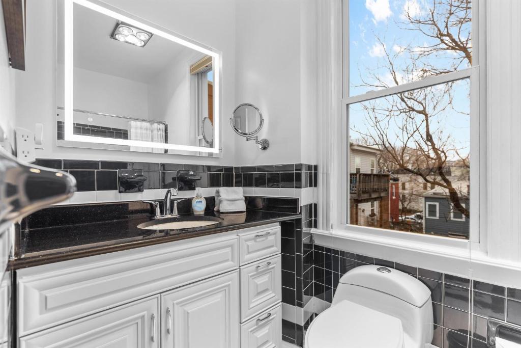 a bathroom with a toilet and a sink and a window at Spacious and Central DC 3-BR Getaway Close to It All in Washington, D.C.
