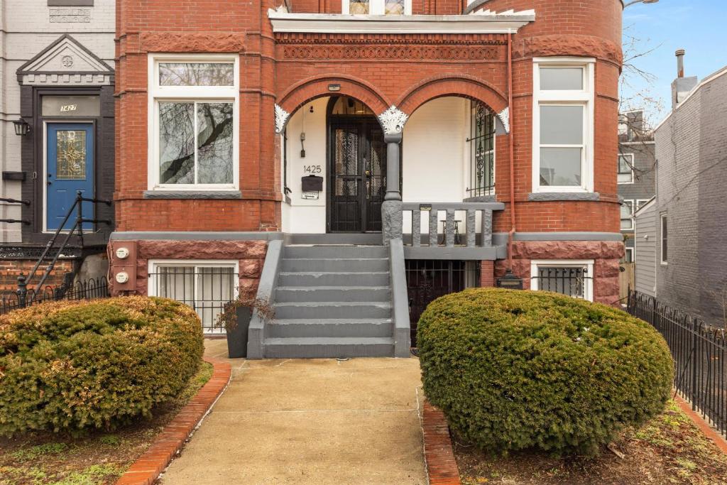 a red brick house with a blue door at Spacious and Central DC 3-BR Getaway Close to It All in Washington, D.C.