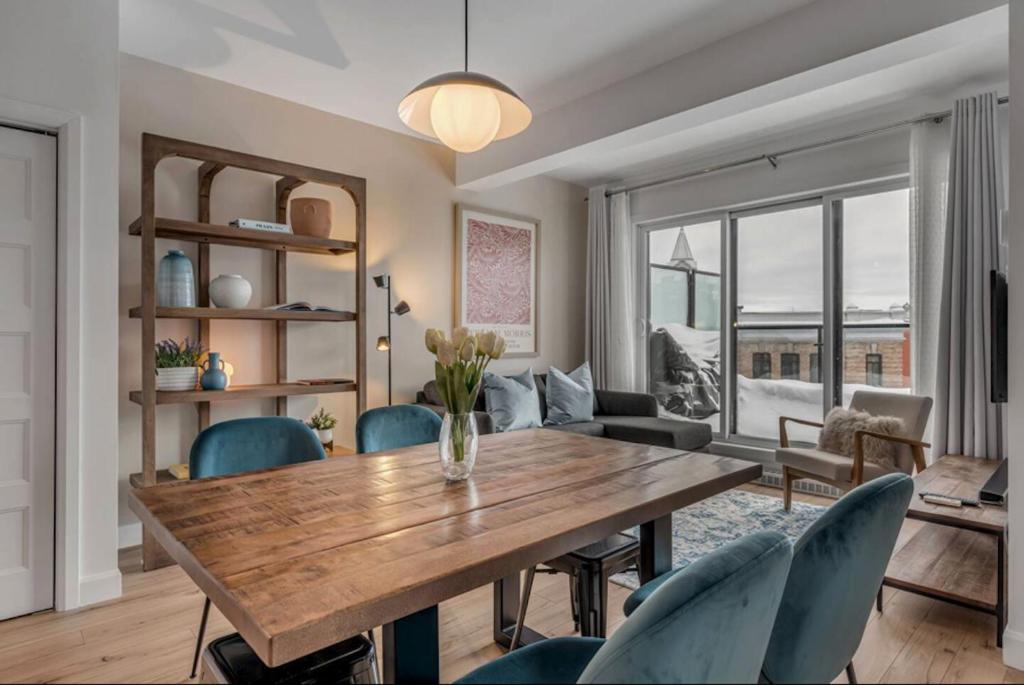 Hotel Initial / Gallery / Qc+Parking, a living room with a wooden table and chairs at Initial / Gallery / Qc+Parking in Quebec City