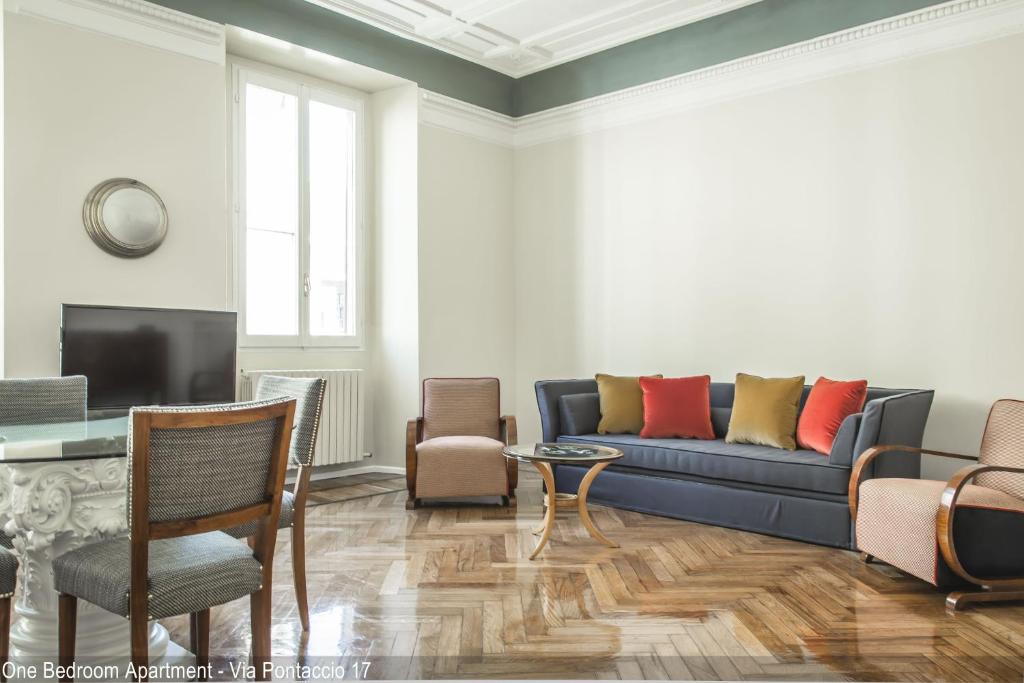 salon z niebieską kanapą i krzesłami w obiekcie Brera Apartments w Mediolanie