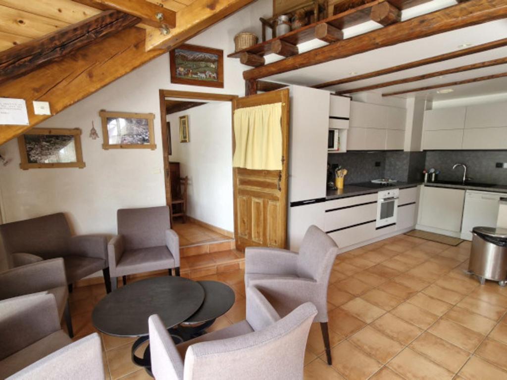 une cuisine avec une table et des chaises dans une pièce dans l'établissement Chalet 11 pers, 5 ch, pied des pistes, balcon, parking, Wi-Fi, cheminée, Serre Chevalier - FR-1-762-27, à Saint-Chaffrey