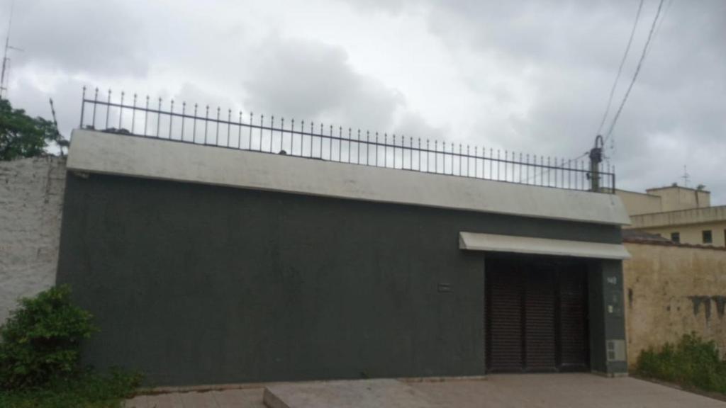 a black building with a fence on top of it at Casa com piscina in Guarujá