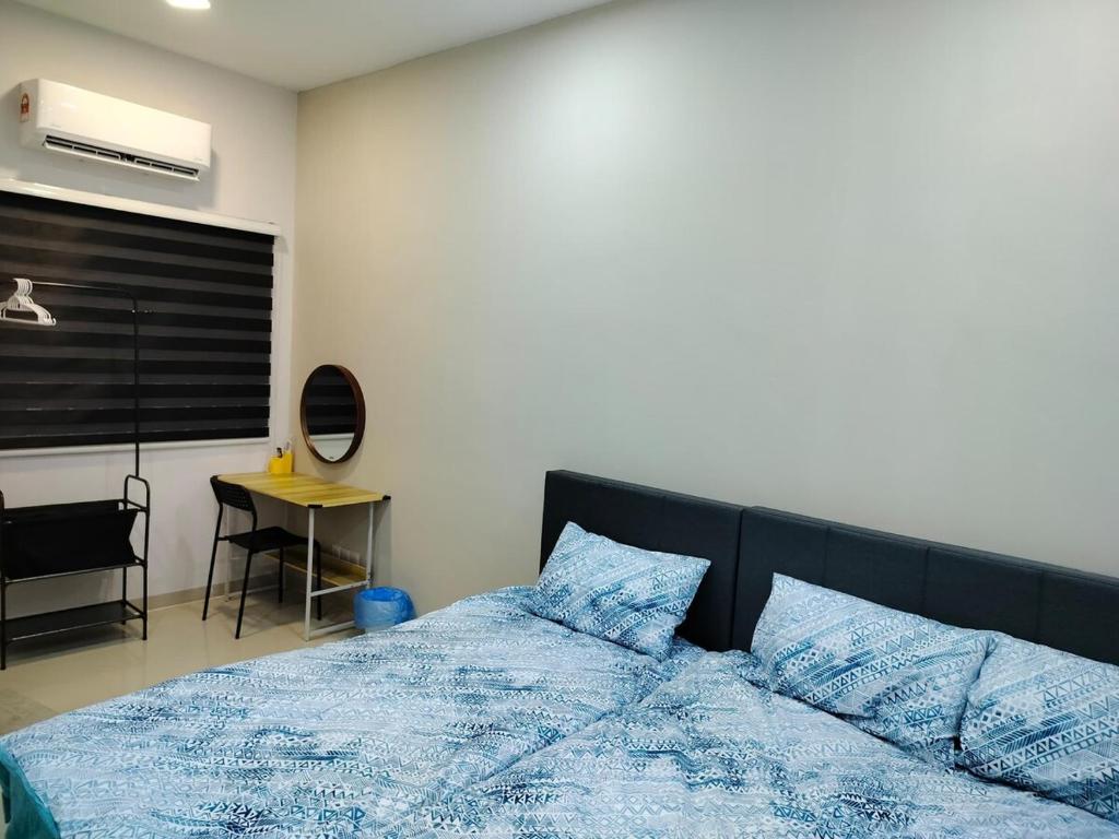 a bedroom with a bed with blue sheets and a desk at KLANG - Enjoy Life Klang Homestay in Klang
