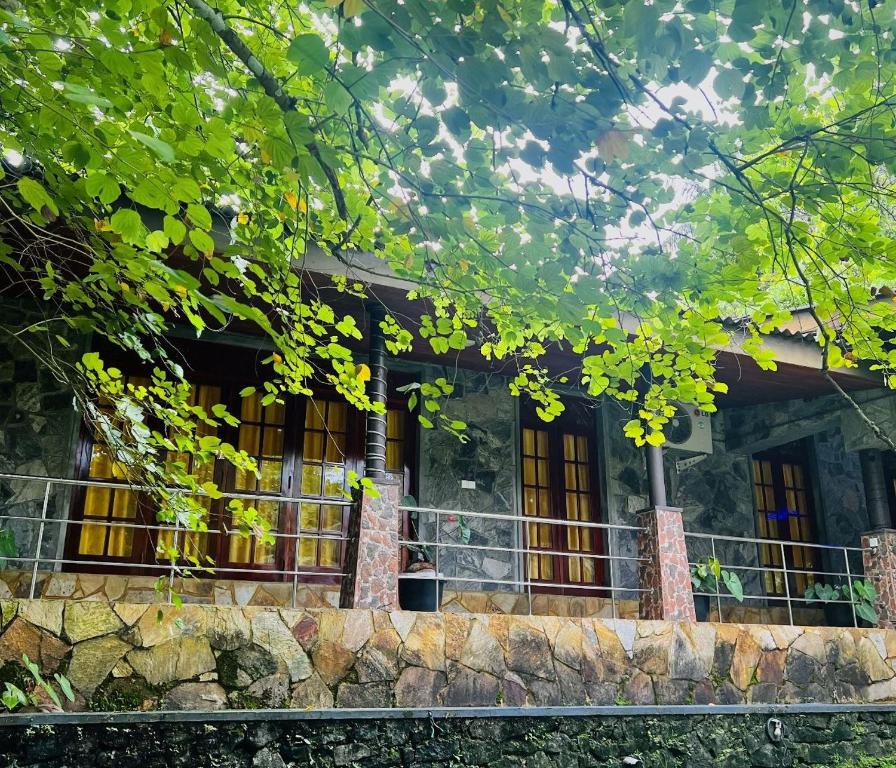 a stone house with yellow windows and a fence at Sisiliyana Stone Resort in Gonapola