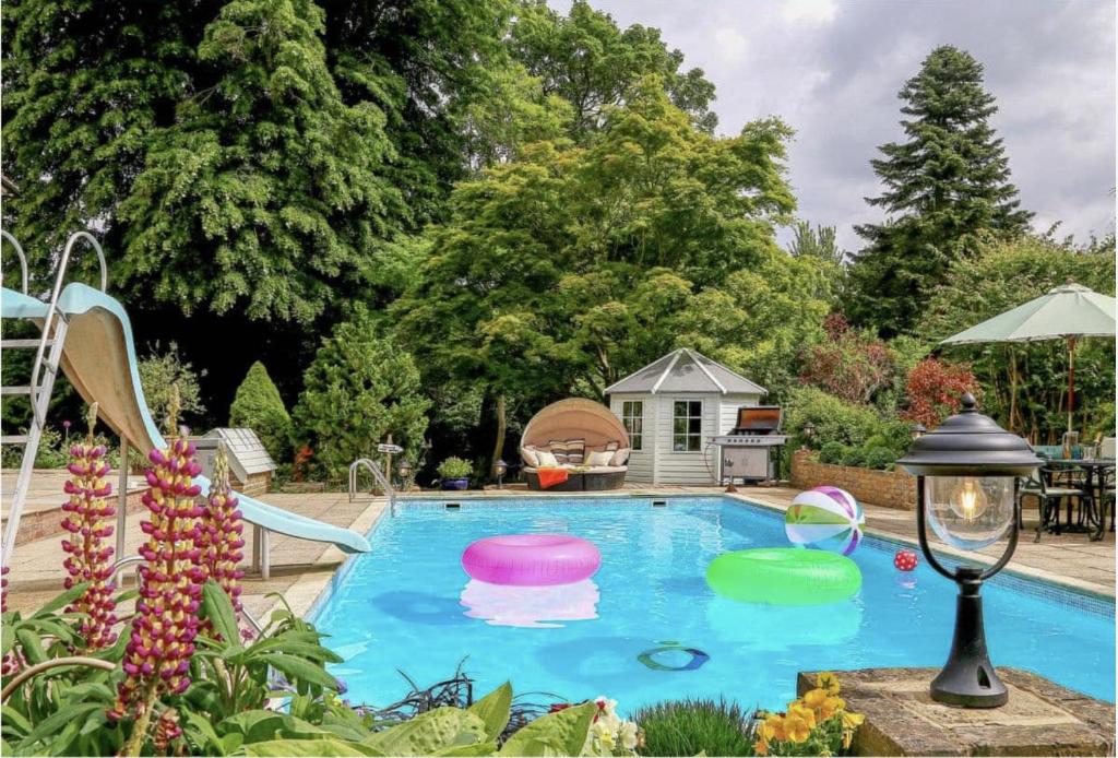 una piscina con cuatro frisbees en un patio en The Manor Coach House, en Canterbury