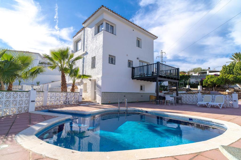 a villa with a swimming pool in front of a house at Villa Mauri Private Pool by Casasol in Nerja
