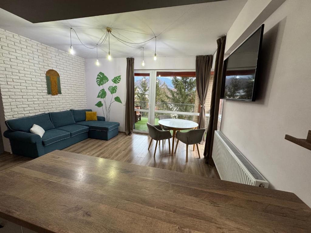 a living room with a blue couch and a table at 4 Seasons Apartment Sinaia in Sinaia