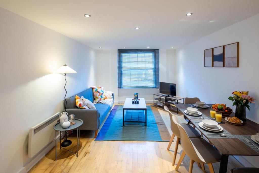 a living room with a blue couch and a table at Central Flat-2Bedrooms-2Bath-By FabAccommodation in Bristol