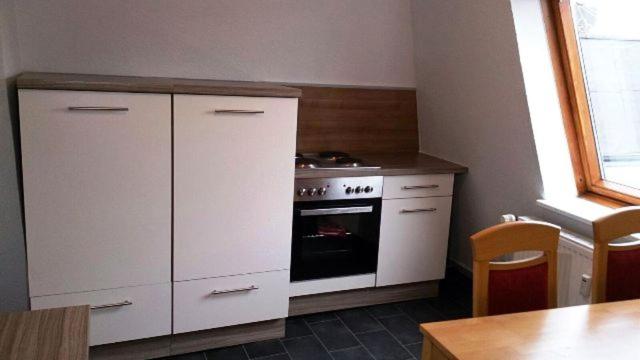 a kitchen with white cabinets and an oven at Rickmersstraße 61 Bremerhaven in Bremerhaven