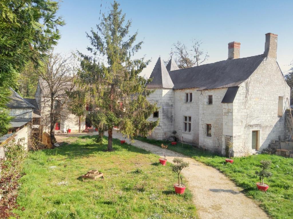 an old stone house with potted plants in a yard at Maison charmante à Courchamps avec vue sur jardin in Courchamps