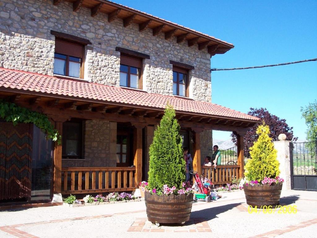 een huis met twee potbomen ervoor bij El Encinar in Tarilonte