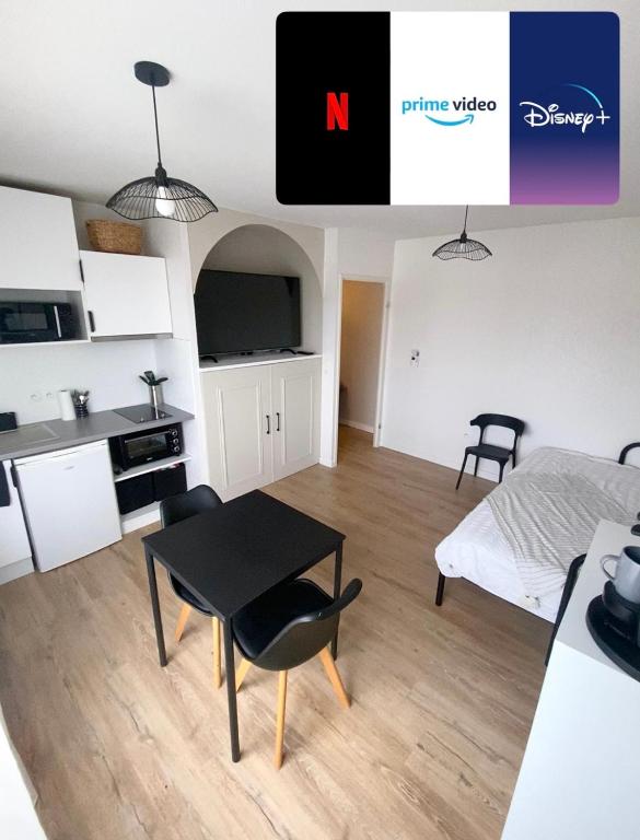Cette chambre comprend une cuisine, une table et un lit. dans l'établissement Appartement T1 Colomiers proche AIRBUS, à Colomiers