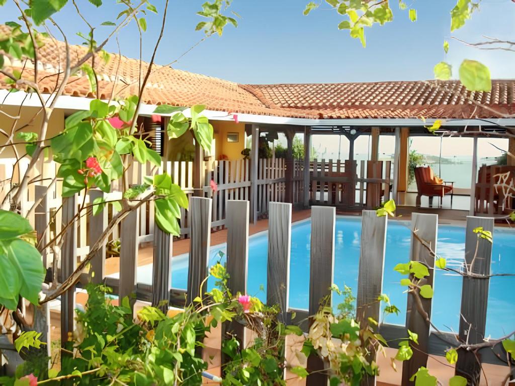 a house with a fence next to a swimming pool at Maison spacieuse avec piscine privée à Le François in Le François