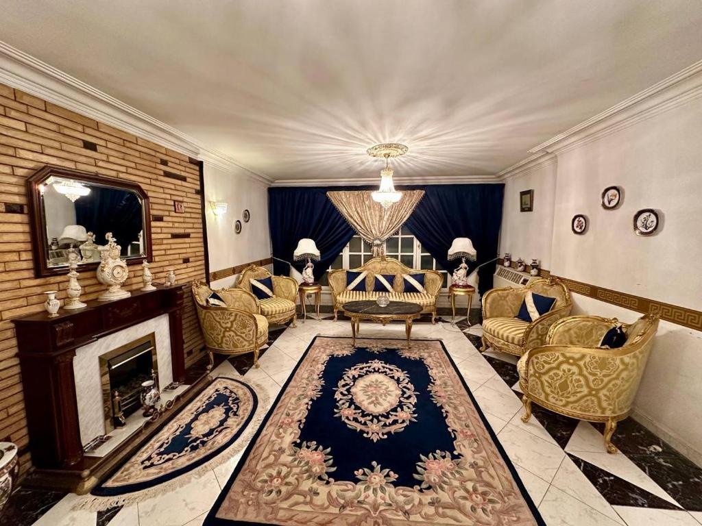 a living room with a fireplace and chairs and a mirror at Luxury Lodge for Men in Cairo