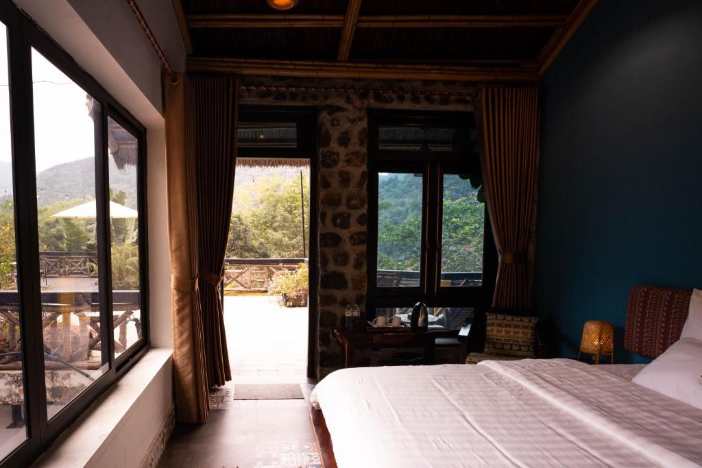 a bedroom with a bed and a large window at Trang An Ecolodge in Ninh Binh