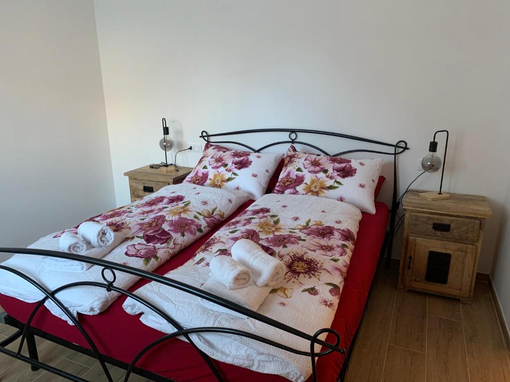 a bed with floral pillows on it in a bedroom at IL COMO' DELLA CIVETTA - Nido del Picchio in Villa di Tirano