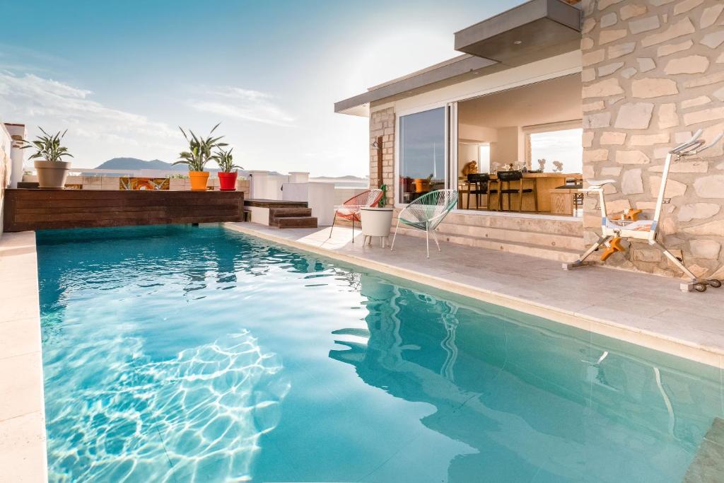 una piscina frente a una casa en Villa Albatros - piscine chauffée, en Saint-Mandrier-sur-Mer
