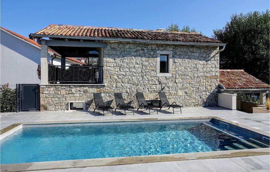 a swimming pool with chairs and a house at Villa Pepa in Zarečje