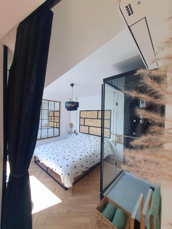 une chambre avec un lit et une paroi vitrée dans l'établissement Love Room Charnelle, Chic, Hammam, Clim, à Chartres