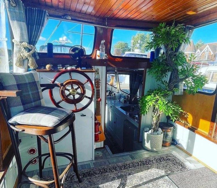 eine Küche mit Pflanzen, einem Tisch und einem Stuhl in der Unterkunft Stunning Classic Dutch Barge near Henley & Marlow in Bourne End