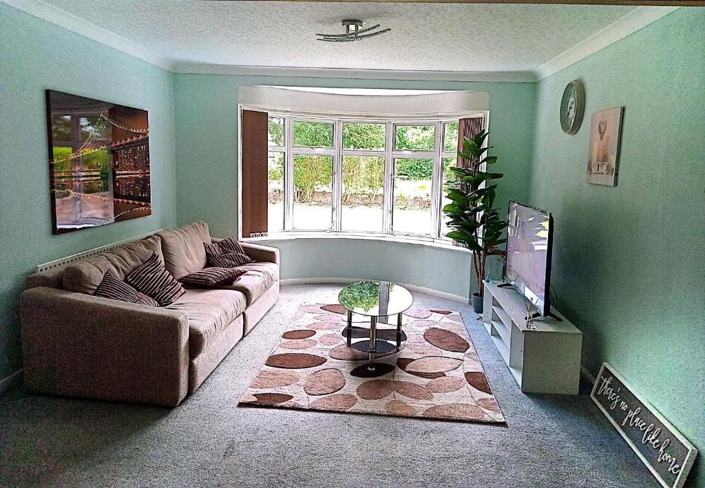 a living room with a couch and a tv at YPCC Accommodations in Bradford