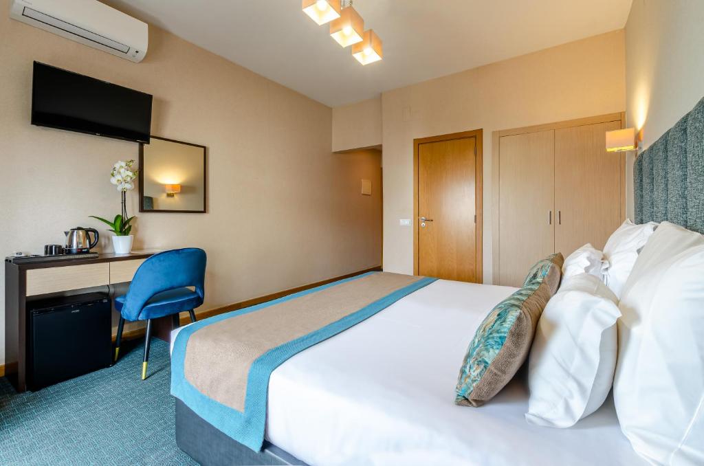 A double room with a desk, tea station, television and built-in wardrobe.