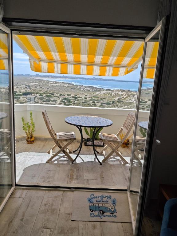 a patio with a table and chairs and an umbrella at BBA Appartement climatisé vue mer Baleal in Ferrel