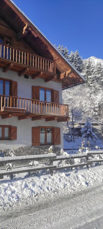une maison dans la neige avec une clôture devant elle dans l'établissement Bilocale relax in Cesana, à Césane