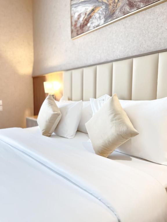Hotel NARS Plus Al Nuzha, a large white bed with white pillows on it at NARS Plus Al Nuzha in Jeddah