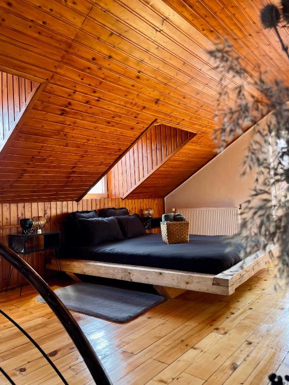 a large bed in a room with a wooden ceiling at Old Town by HYCO in Sighişoara